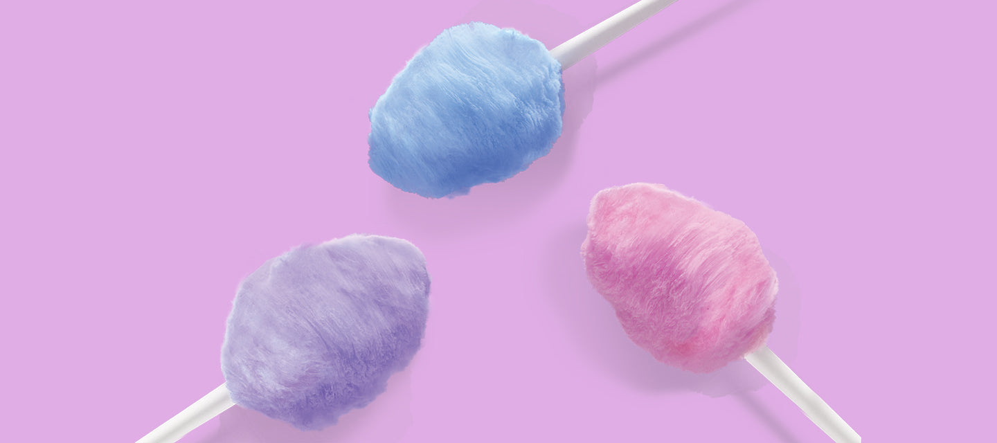  Blue, purple, and pink cotton candy cones on a light pink background.