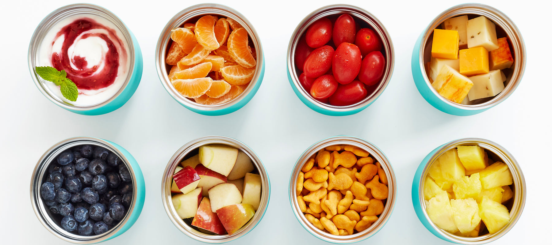  An aerial shot of the ZOKU Neat Stack Food Jars, packed with a an assortment of different snacks.