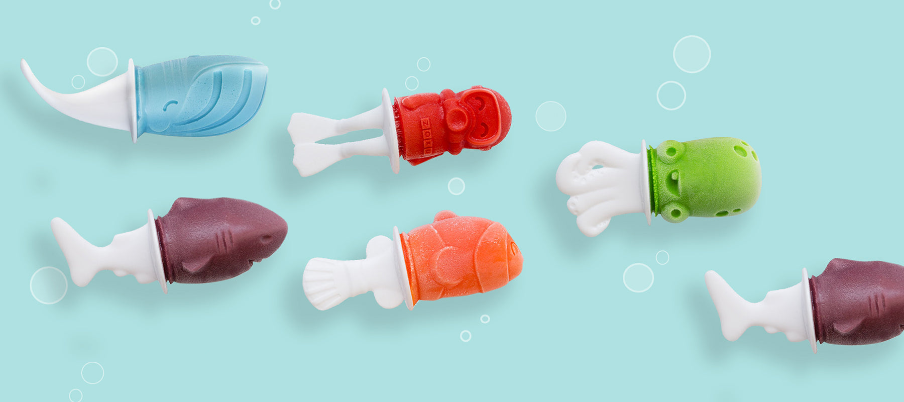 An image of the ZOKU Fish Pop Molds featuring under-the-sea creatures: Shark, Clownfish, Octopus, Whale, Puffer Fish and a Scuba Diver. They are all swimming together in a cute display against a light blue background that looks just like the ocean.