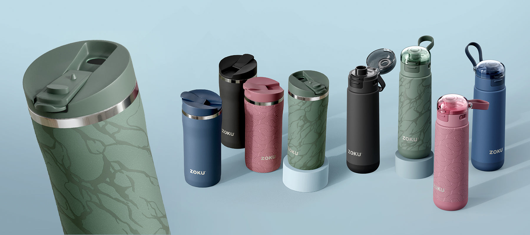  A close-up of ZOKU 18oz Stainless Steel Vacuum Insulated Bottle in Aqua, laid out over a woven placemat and plaid white and navy napkin.